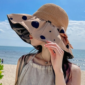 Détail d'un chapeau de soleil en paille avec bord à pois bleus et doublure anti-UV