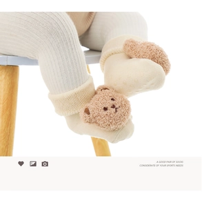 Dettaglio calzini invernali neonato con orsetto di peluche e suola antiscivolo puntinata