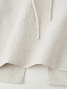 Detailed macro view of cream cotton linen fabric texture with drawstring and hem split