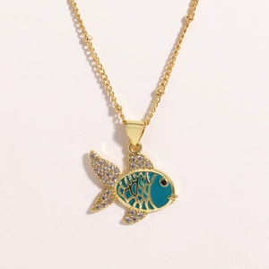 Detailed shot of golden fish pendant with blue enamel and sparkling cubic zirconia stones