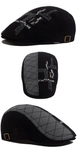 Detail of vintage patchwork newsboy cap with embroidery, quilted fabric, and side buckle