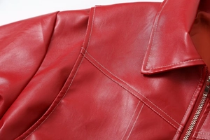 Close-up of red leather jacket with white stitching details and metal zipper design