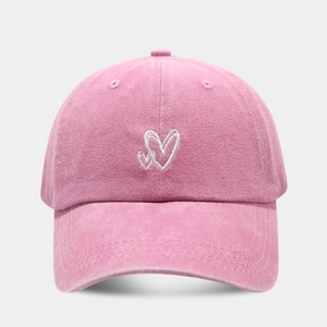 Detail of pink washed cotton baseball cap with white double heart embroidery