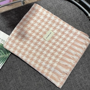 Detail of pink and white houndstooth cashmere scarf with soft fringes and label