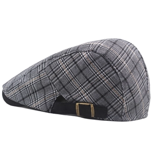Detail view of adjustable strap and copper buckle on grey plaid newsboy cap