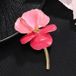 Vintage enamel iris flower brooch in pink and gold on a professional black textured base
