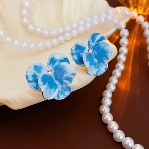 Eleganti orecchini a fiore in smalto blu con cristallo su sfondo di conchiglia