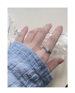 Dettaglio dell'anello in argento S925 con opale blu a cuore indossato sulla mano