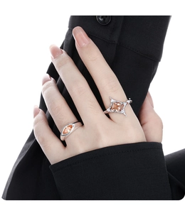 Detail of silver rings featuring marquise-cut and square-cut orange gemstones on fingers