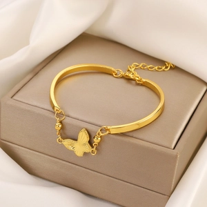 Elegant gold butterfly bracelet with engraved wings on luxury jewelry display
