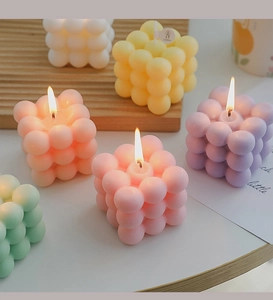 Macro shot of bubble cube scented candles in various macaron colors on a wooden tray
