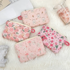 Flat lay of pink quilted cotton pouches with cartoon rabbit and floral patterns