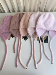 Detailansicht weicher Angora-Ohrenschützer-Mützen in sanften Pastelltönen wie Rosa und Beige