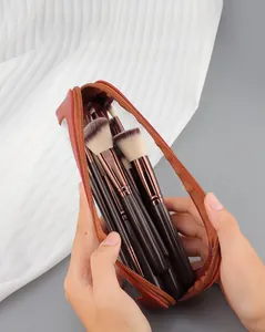 Close-up of a 10-piece professional makeup brush set with a semi-transparent zip storage bag