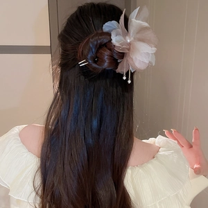 Détail d'épingle à cheveux fleur en tissu rose avec pompons de perles et pétales superposés