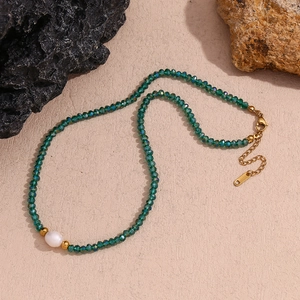 Detail of green crystal beads and large white freshwater pearl on beaded necklace