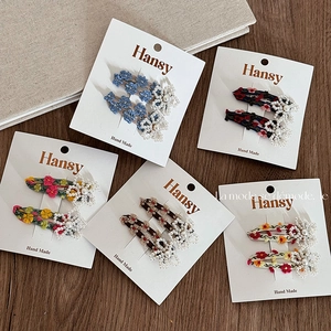 Five pairs of floral embroidered hair clips with pearls on elegant display cards