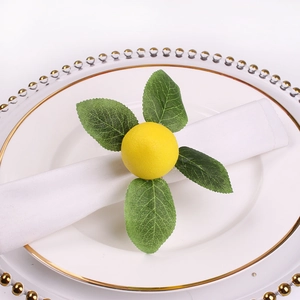 Handmade lemon napkin ring with green leaves on a white ceramic plate with gold beads