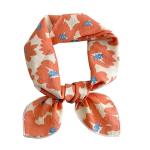 Floral cotton linen scarf featuring orange flower prints and blue centers on beige background