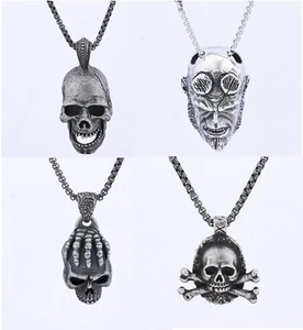 Detail of four antique silver skull and devil pendants featuring gothic skeleton designs