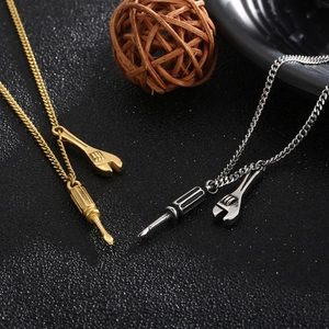 Detailed view of gold and silver necklaces with miniature wrench and screwdriver tool pendants