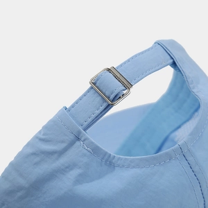 Detail of adjustable metal buckle and stitching on light blue breathable baseball cap