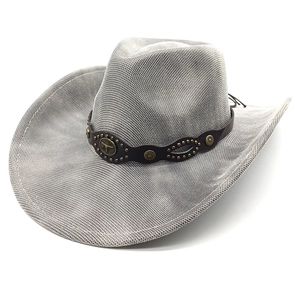 Detail of western woven cowboy hat with bronze bull emblem and studded leather band