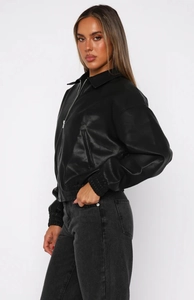 Détails d'un blouson motard en simili cuir noir avec col à revers et zips métalliques