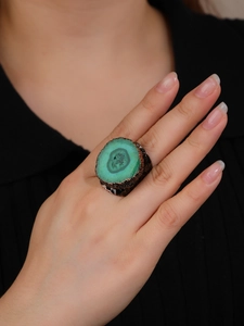 Exaggerated wide bronze ring with green crystal sunflower centerpiece on hand