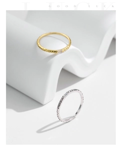 Detail of s925 silver rings with gold finish and textured hammer texture with single gem