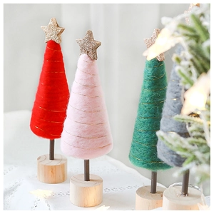 Detail of pink and red wool felt Christmas trees with golden stars on wooden bases