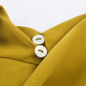 Detailed macro view of mustard yellow woven fabric with two white circular buttons