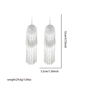 Detail view of silver tassel earrings with bohemian engraved disk and dimension markings