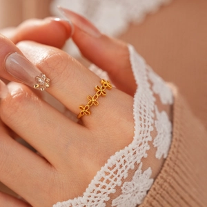 Gros plan d'une bague fleurie évidée plaquée or portée à la main style vintage