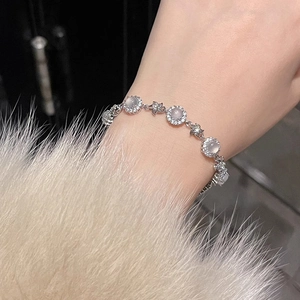 Elegant zircon flower bracelet with gray moonstone on a silver chain worn with fur