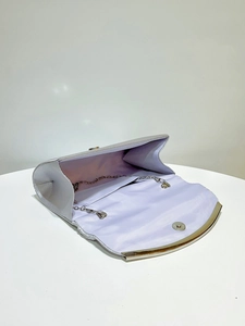 Detail view of silver evening clutch bag opening showing metallic chain and interior