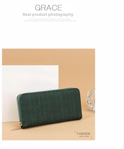 Detail of dark green women's long wallet featuring vertical texture and golden zipper hardware