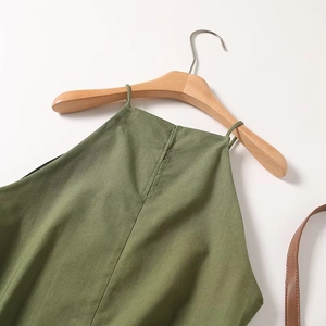 Detail of olive green cotton linen halter top fabric texture and natural wood hanger