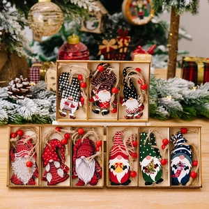 Christmas gnome wooden ornaments set in storage box with rustic pine tree background
