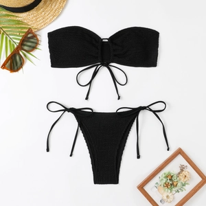 Close-up of black seersucker bikini set with side-tie bottoms and textured fabric