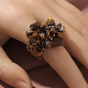 Detailed macro view of bohemian cluster ring with tiger eye stones and golden beads