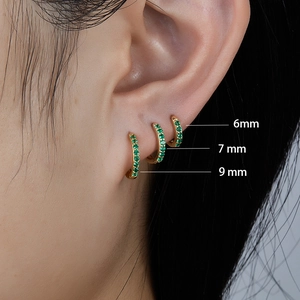 Three sizes of gold silver earrings with green zircon shown on ear, 6mm 7mm 9mm
