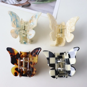 Set of 4 butterfly hair claws in marble, beige, tortoiseshell, and checkerboard patterns