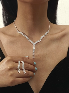 Silver necklace and earring set with shimmering crystals worn on a model for gala