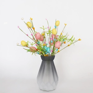 Rami di uova di Pasqua color pastello in un vaso di vetro smerigliato sfumato sfaccettato
