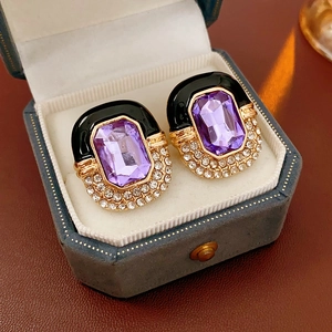 Close-up of vintage square purple stone earrings with rhinestones on blue velvet box