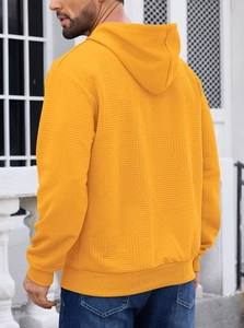 Detail of men's mustard yellow hoodie showing long sleeves and premium jacquard texture