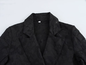 Close-up of the notch lapel and jacquard texture on this black tailored coat