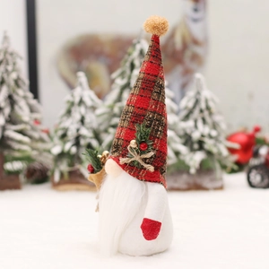 Christmas gnome doll with plaid hat and pine accents on a snowy winter background