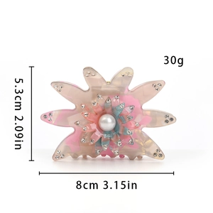 Détail de la pince à cheveux fleur rose avec strass brillants et une grande perle centrale
